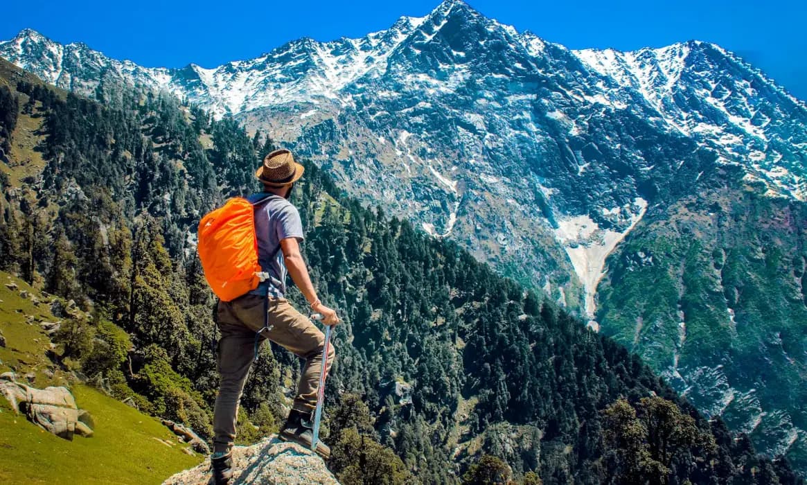 A hiker walking through a mountainous terrain, perfect for trekking enthusiasts.